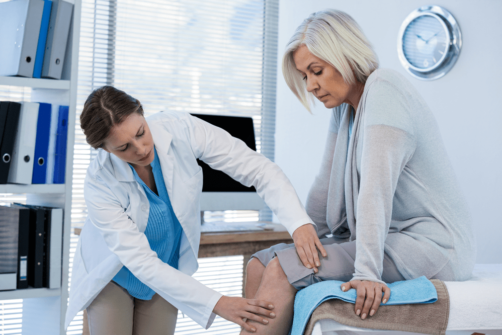 Un médico examina a un paciente con artrosis que necesita terapia